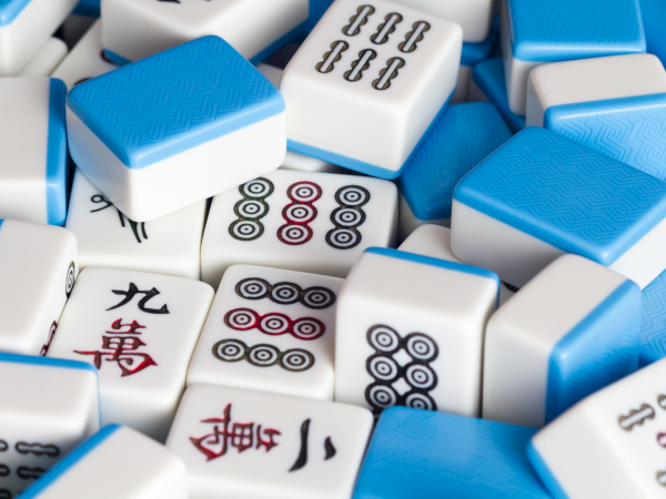 A pile of blue and white domino tiles with various pips and patterns scattered chaotically.